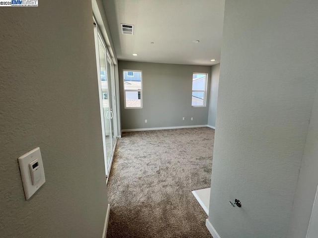 hallway with light colored carpet