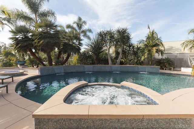 view of swimming pool featuring pool water feature and an in ground hot tub