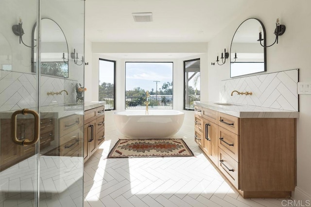 bathroom featuring vanity, decorative backsplash, and plus walk in shower