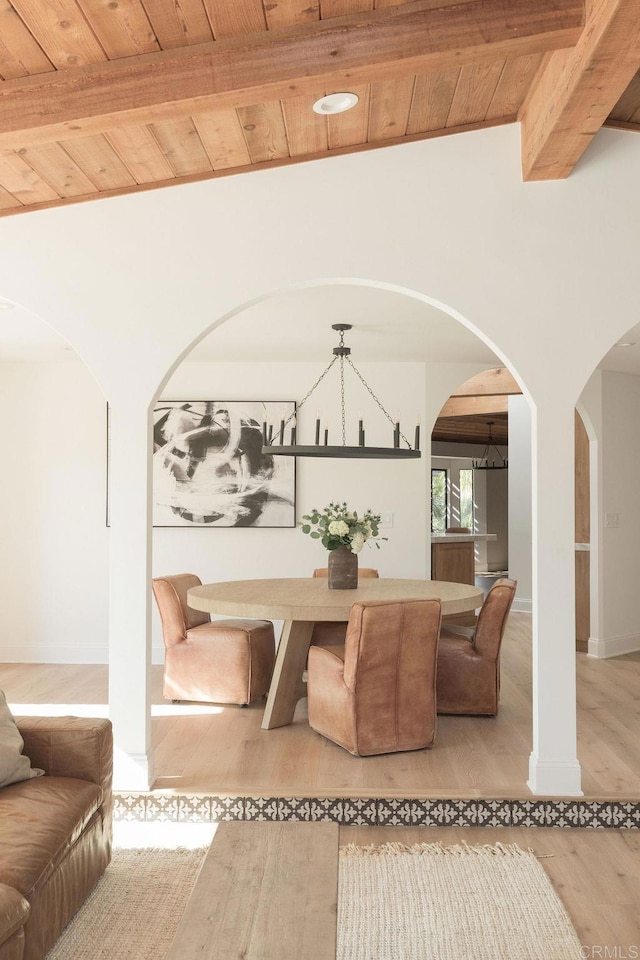 living area featuring wood ceiling, vaulted ceiling with beams, arched walkways, and wood finished floors