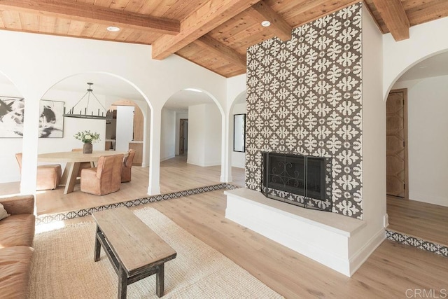 living room with wood ceiling, baseboards, arched walkways, and wood finished floors