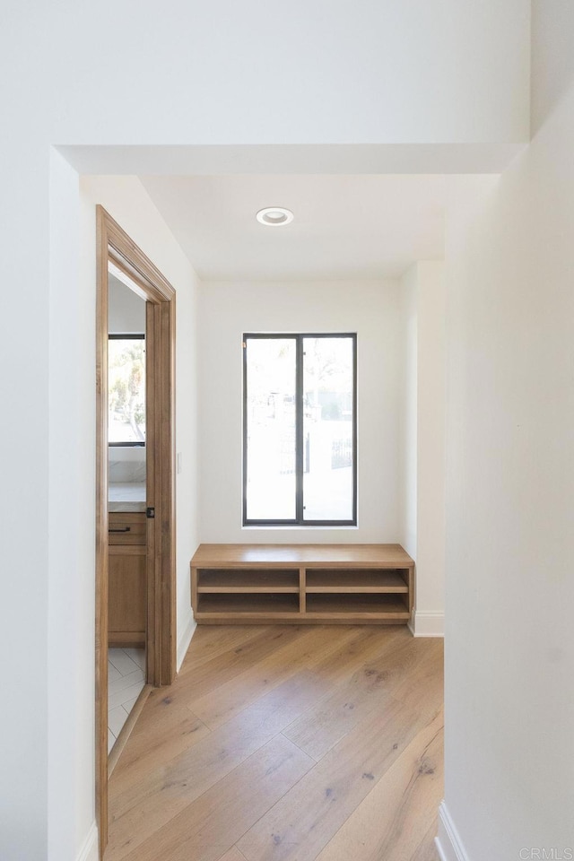 hall with recessed lighting, baseboards, a wealth of natural light, and light wood-type flooring