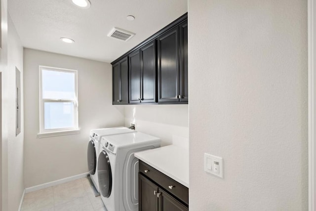 laundry room with separate washer and dryer, light tile patterned floors, and cabinets