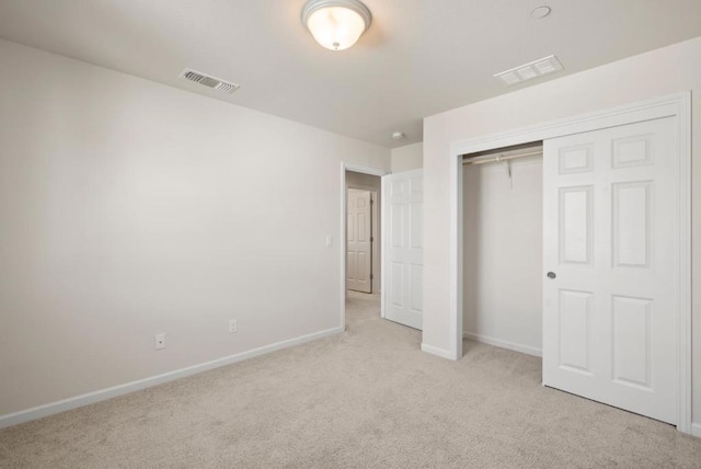 unfurnished bedroom featuring a closet and light carpet