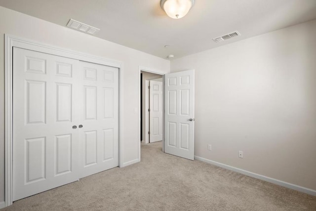 unfurnished bedroom with a closet and light colored carpet