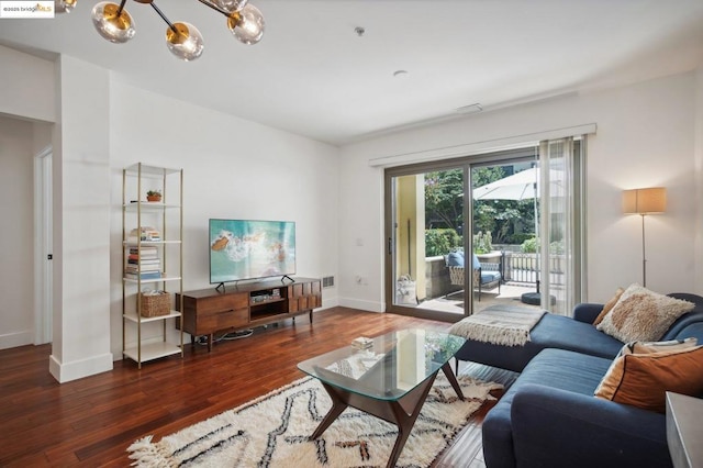 living room featuring dark hardwood / wood-style flooring and an inviting chandelier