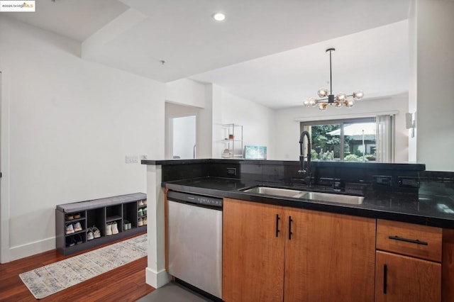 kitchen with a notable chandelier, dark wood-type flooring, stainless steel dishwasher, and sink