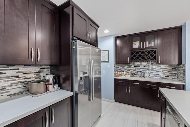 kitchen with backsplash, dark brown cabinets, and stainless steel fridge