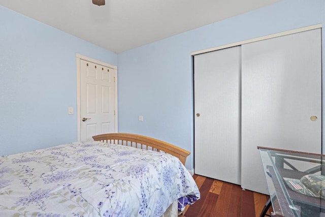 bedroom with dark wood-type flooring, a closet, and ceiling fan