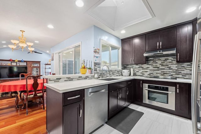 kitchen featuring pendant lighting, sink, appliances with stainless steel finishes, tasteful backsplash, and a chandelier