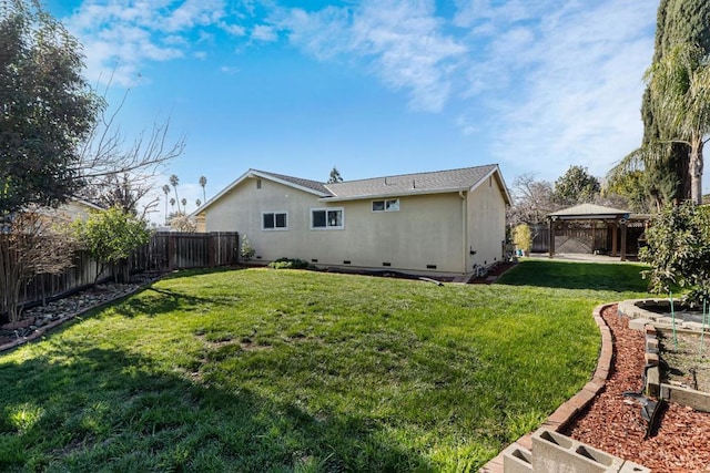 rear view of house with a gazebo and a yard