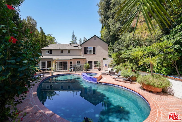 view of swimming pool with an in ground hot tub and a patio area