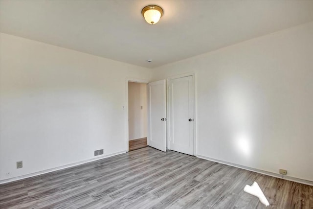 unfurnished bedroom featuring light hardwood / wood-style flooring and a closet