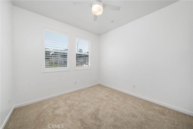 spare room with ceiling fan and light colored carpet