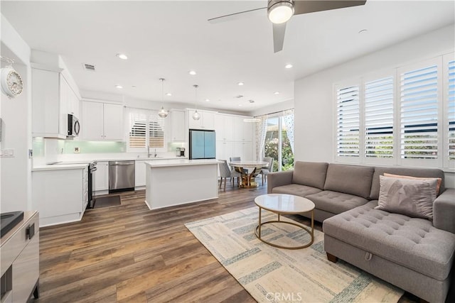 living room with ceiling fan and dark wood-type flooring