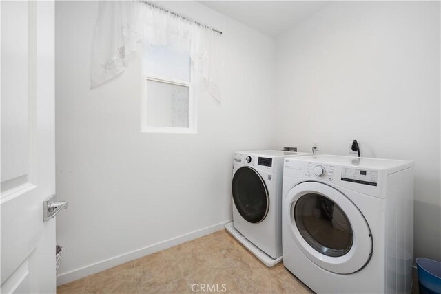 laundry room featuring light tile patterned floors and washing machine and clothes dryer