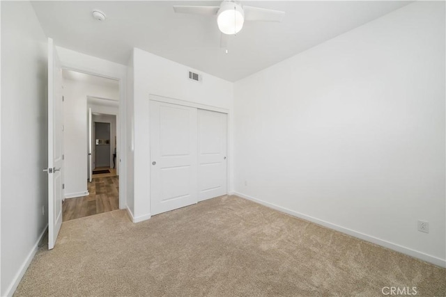 unfurnished bedroom featuring ceiling fan, a closet, and carpet flooring