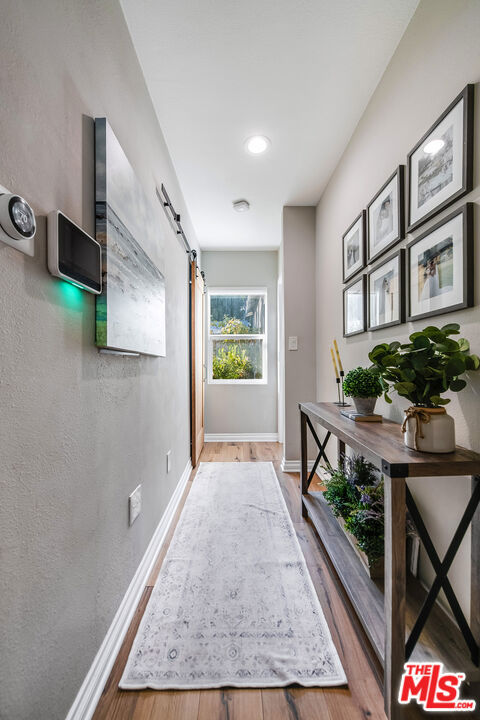 hallway with hardwood / wood-style flooring and a barn door