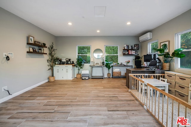 office space with plenty of natural light and a wall mounted AC