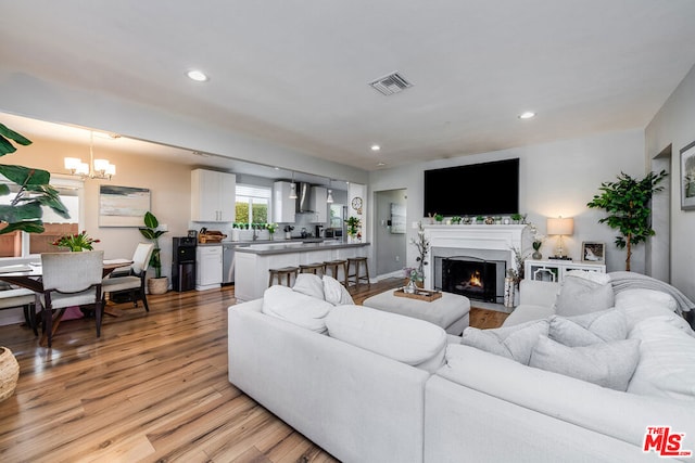 living room featuring light hardwood / wood-style floors and a notable chandelier