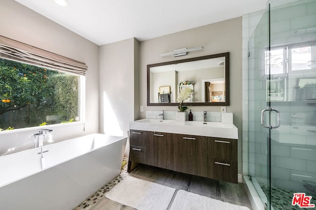 bathroom with independent shower and bath, hardwood / wood-style floors, and vanity