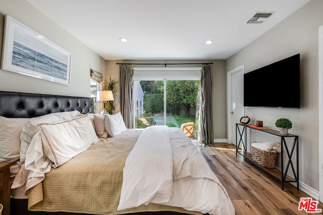 bedroom with access to exterior and wood-type flooring