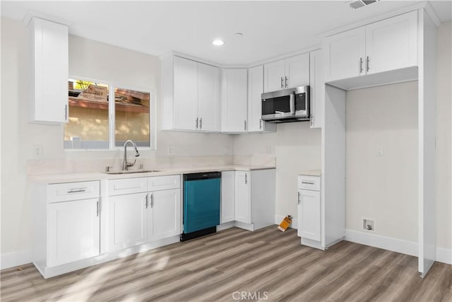 kitchen with sink, white cabinets, dishwasher, and light wood-type flooring