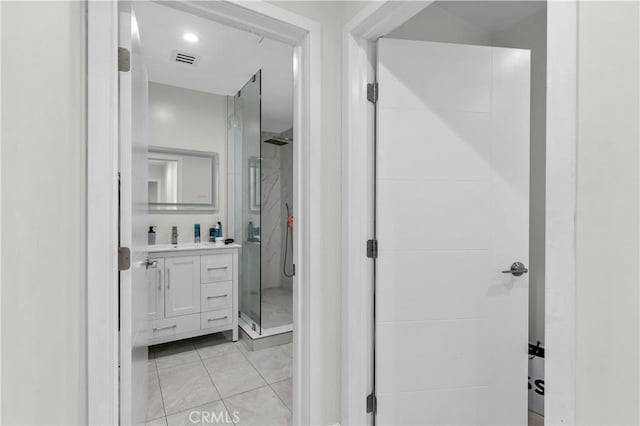 bathroom featuring tile patterned flooring, a shower with door, and vanity