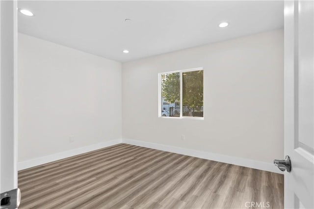 unfurnished room with hardwood / wood-style flooring