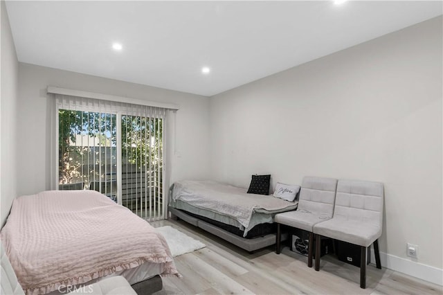 bedroom with access to exterior and light hardwood / wood-style floors