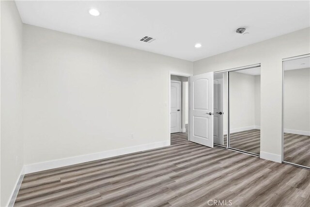 unfurnished bedroom with hardwood / wood-style floors