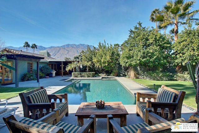 view of swimming pool with a lawn, a mountain view, and a patio area