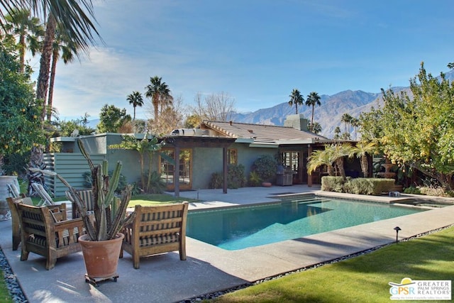 view of pool with a mountain view and a patio area