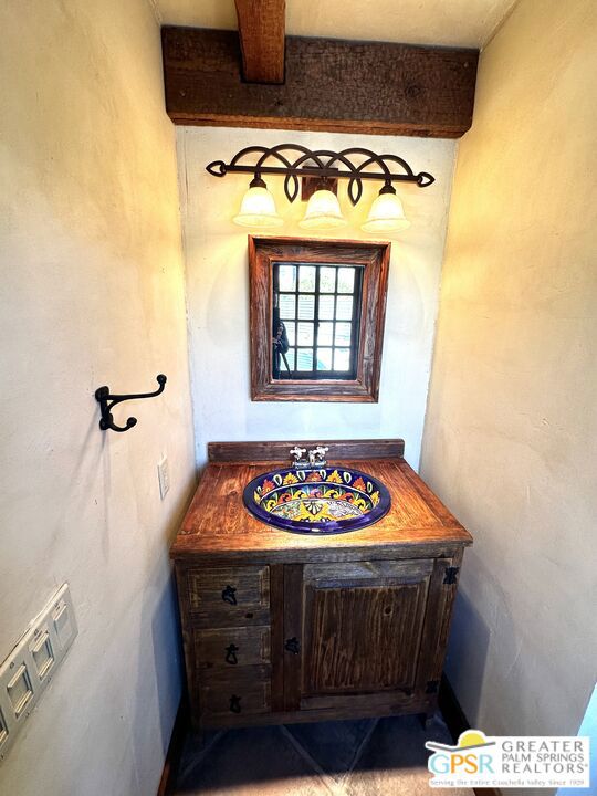 bathroom with vanity and beam ceiling