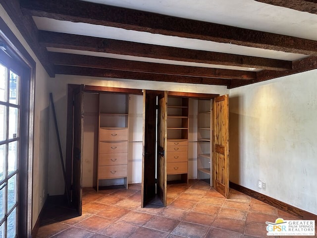 unfurnished bedroom featuring beamed ceiling