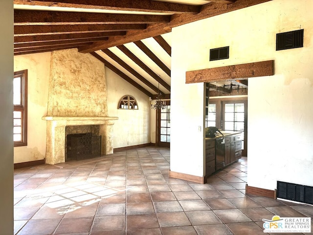 unfurnished living room with a fireplace, beam ceiling, and high vaulted ceiling