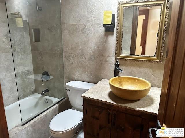 full bathroom featuring tile walls, backsplash, tiled shower / bath, toilet, and vanity