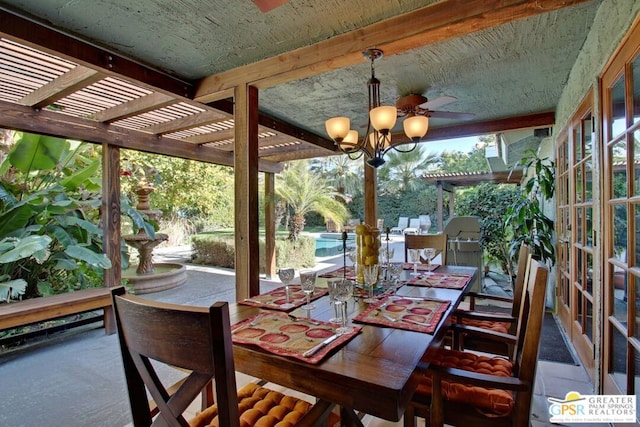 sunroom / solarium with ceiling fan with notable chandelier and beamed ceiling