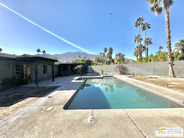 view of pool with a diving board, a mountain view, and a patio area