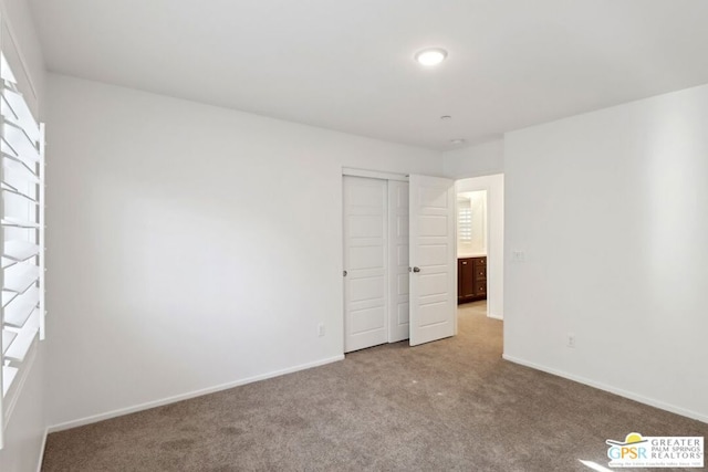 unfurnished bedroom featuring light carpet and a closet