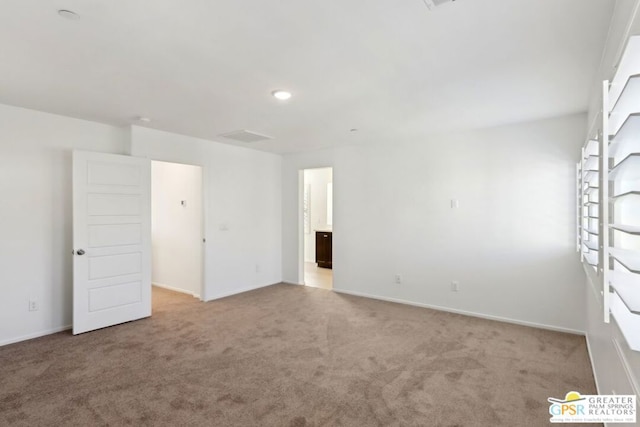 spare room featuring light colored carpet