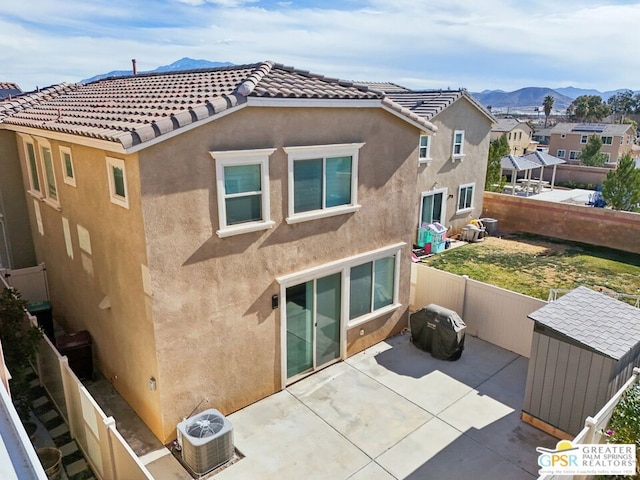 back of house with a mountain view and a patio