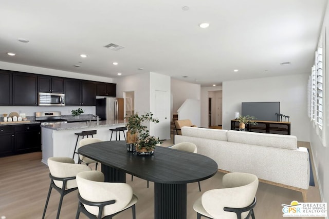 dining area with light hardwood / wood-style flooring and sink