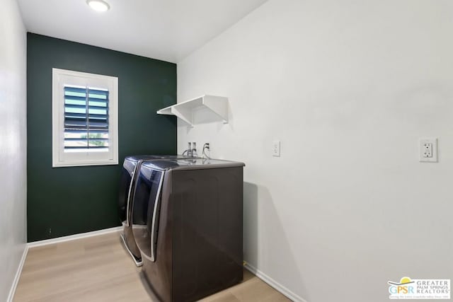 laundry room with washer and clothes dryer and light hardwood / wood-style floors