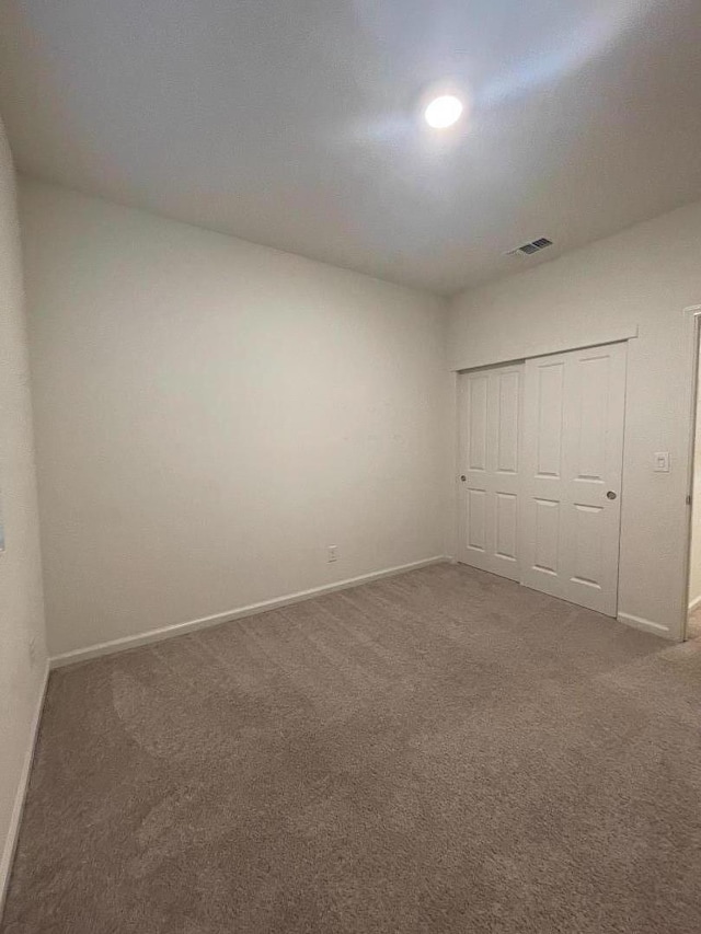 unfurnished bedroom featuring a closet and carpet flooring