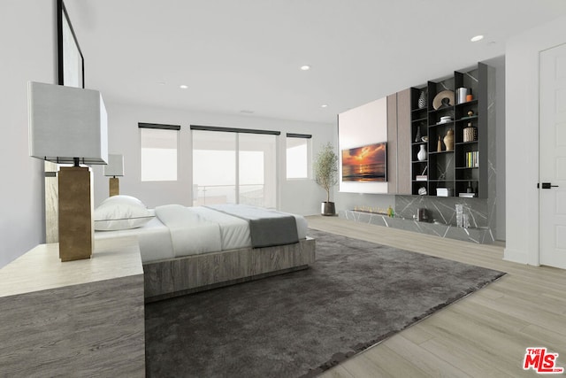 bedroom featuring a barn door and light wood-type flooring