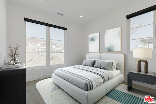 carpeted bedroom featuring multiple windows