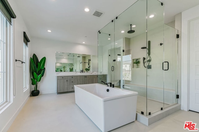 bathroom with vanity, concrete flooring, and shower with separate bathtub