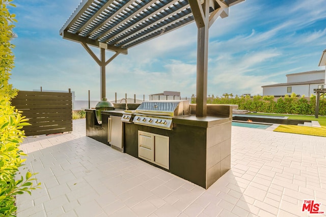 view of patio / terrace featuring grilling area, a pergola, and exterior kitchen