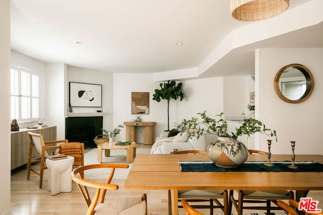 sitting room with a tiled fireplace and light hardwood / wood-style floors